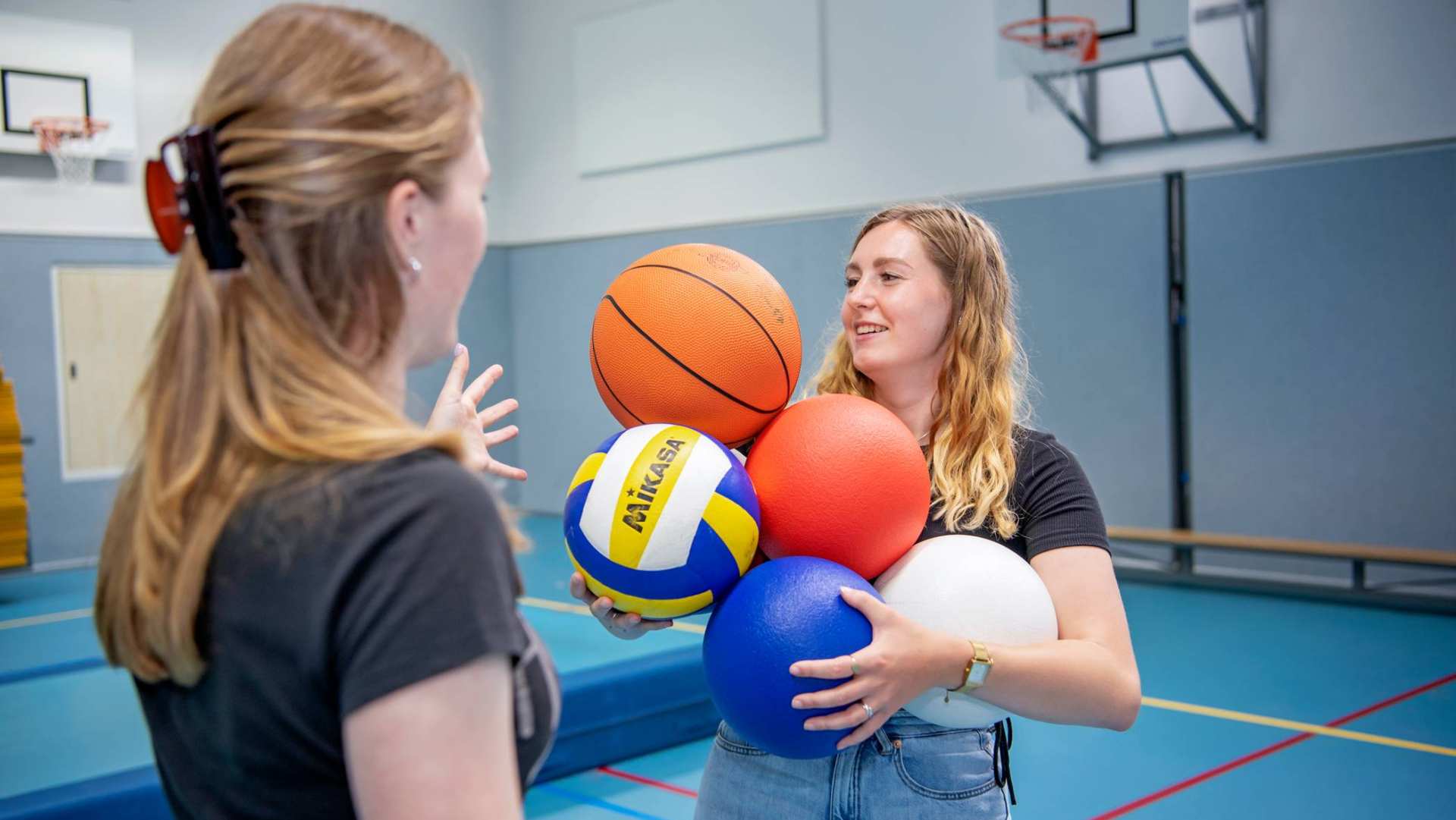 2 meisjes met ballen in gymlokaal