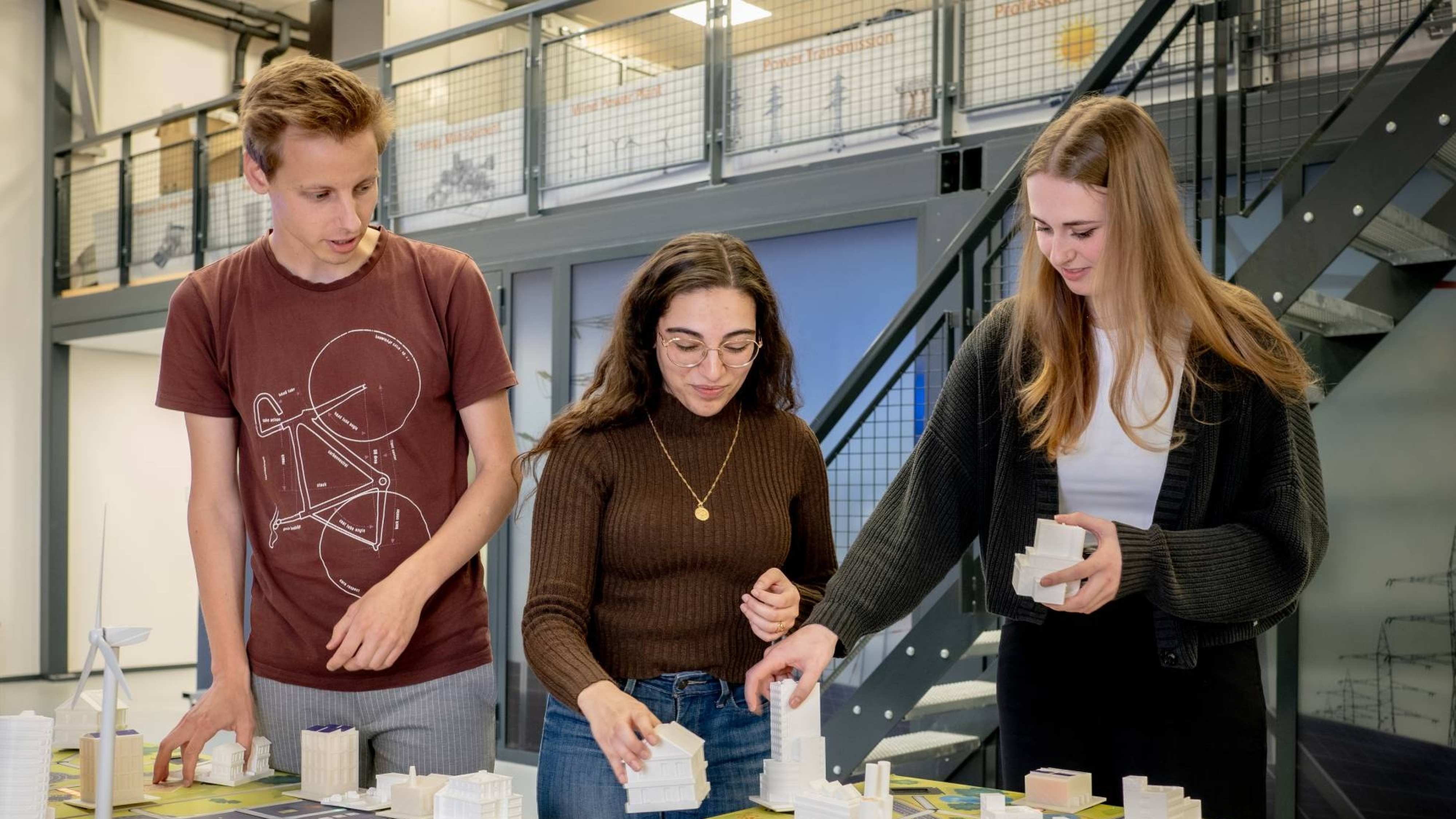 Drie studenten van de Master Engineering Systems werken aan de Smart Grid-tafel