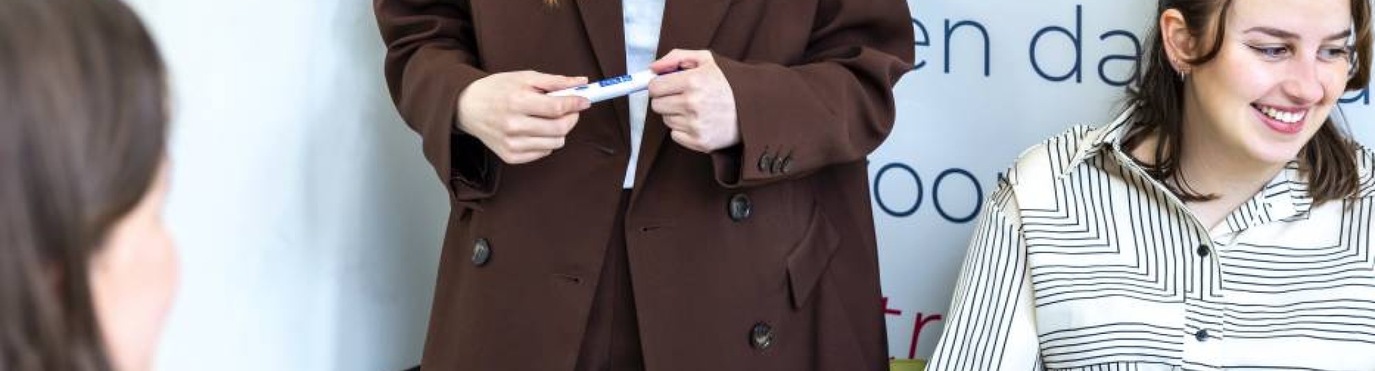 Student wijst iets aan het op het bord