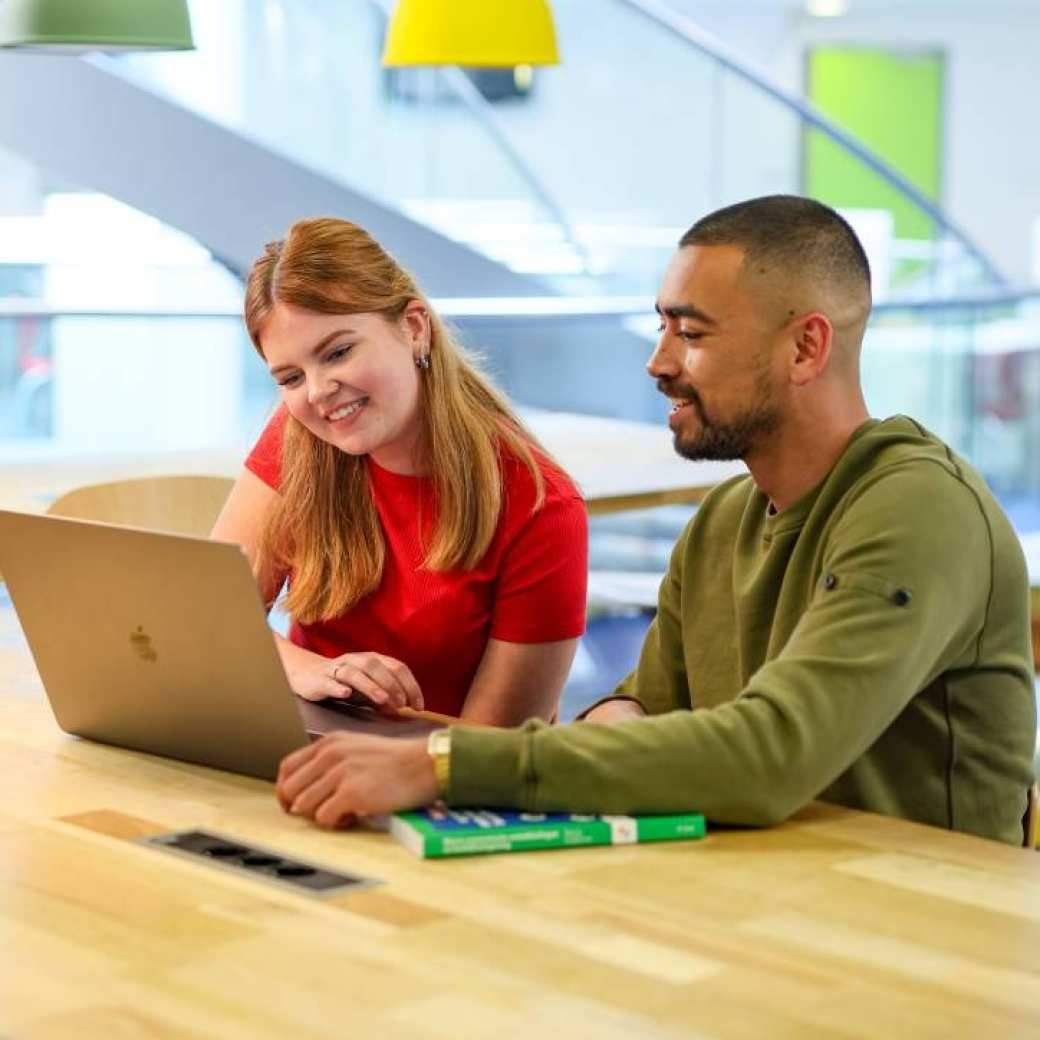 twee studenten werken samen achter een laptop