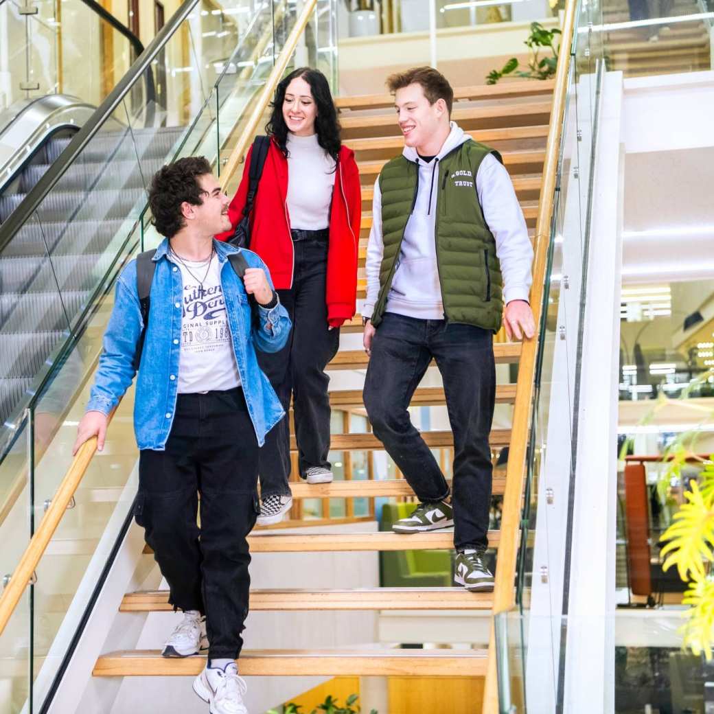 Drie studenten lopen de trap af in het I/O gebouw op de HAN campus in Nijmegen.