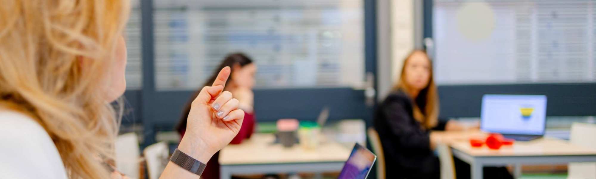 Studenten van de bachelor Commerciële Economie deeltijd, duaal in gesprek tijdens college.