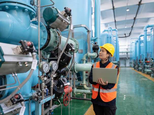 Vrouwelijke engineer met laoptop in chemische fabriek