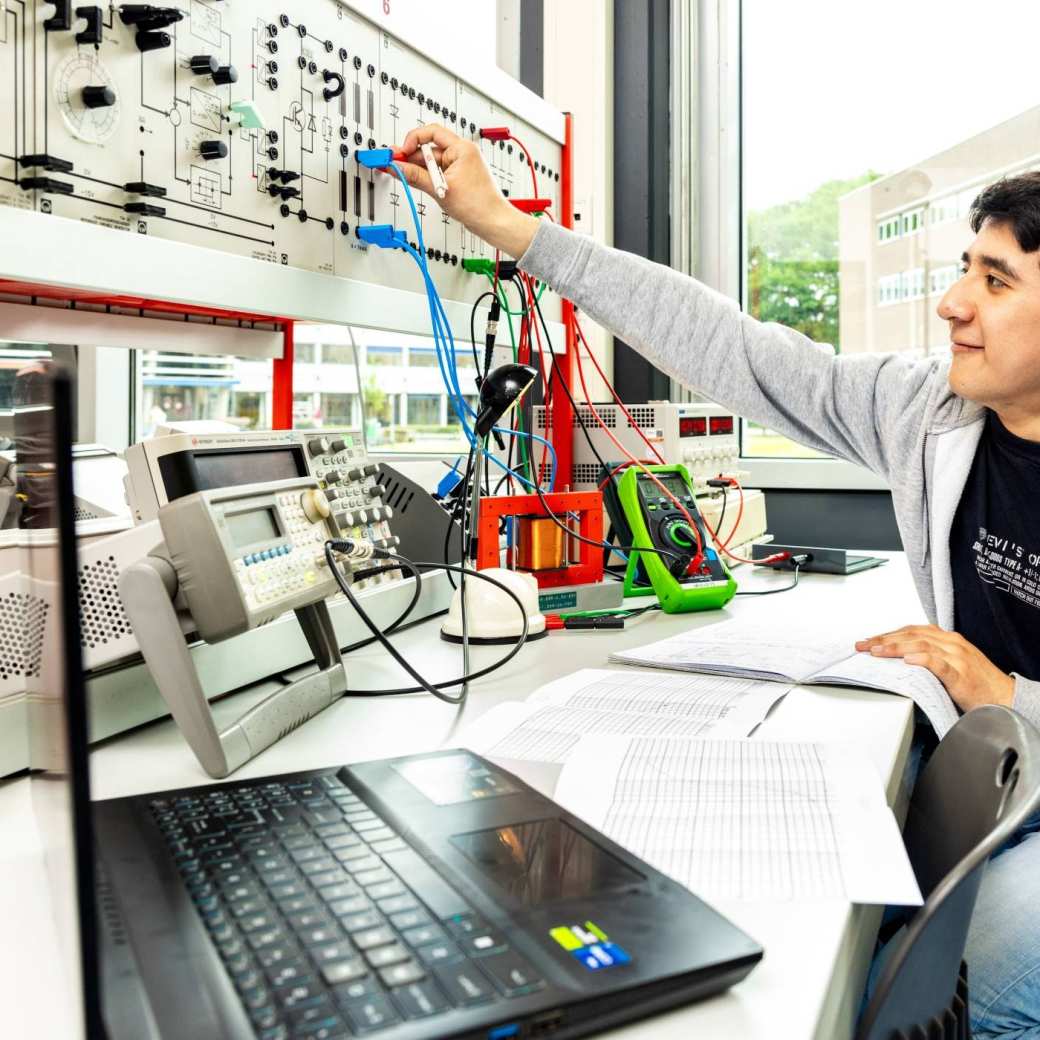 Een student elektrotechniek doet een netwerkpracticum.