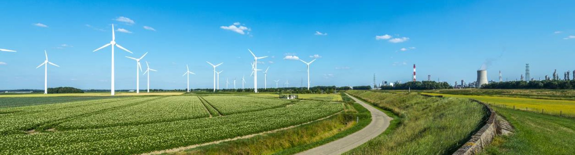 Nederlands landschap met blauwe lucht, windmolens en energiecentrale
