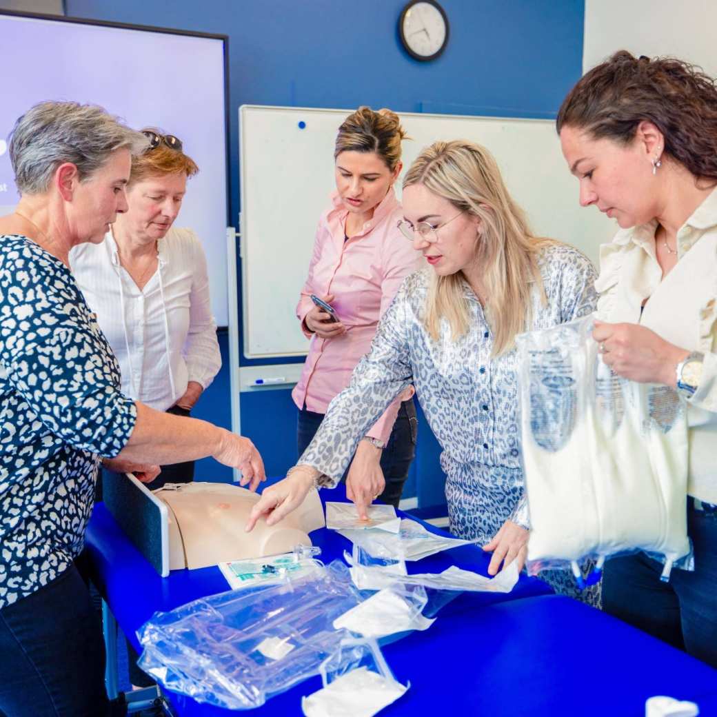 Studenten van technische thuiszorg die aan het praten zijn naast een ziekenhuisbed met patient