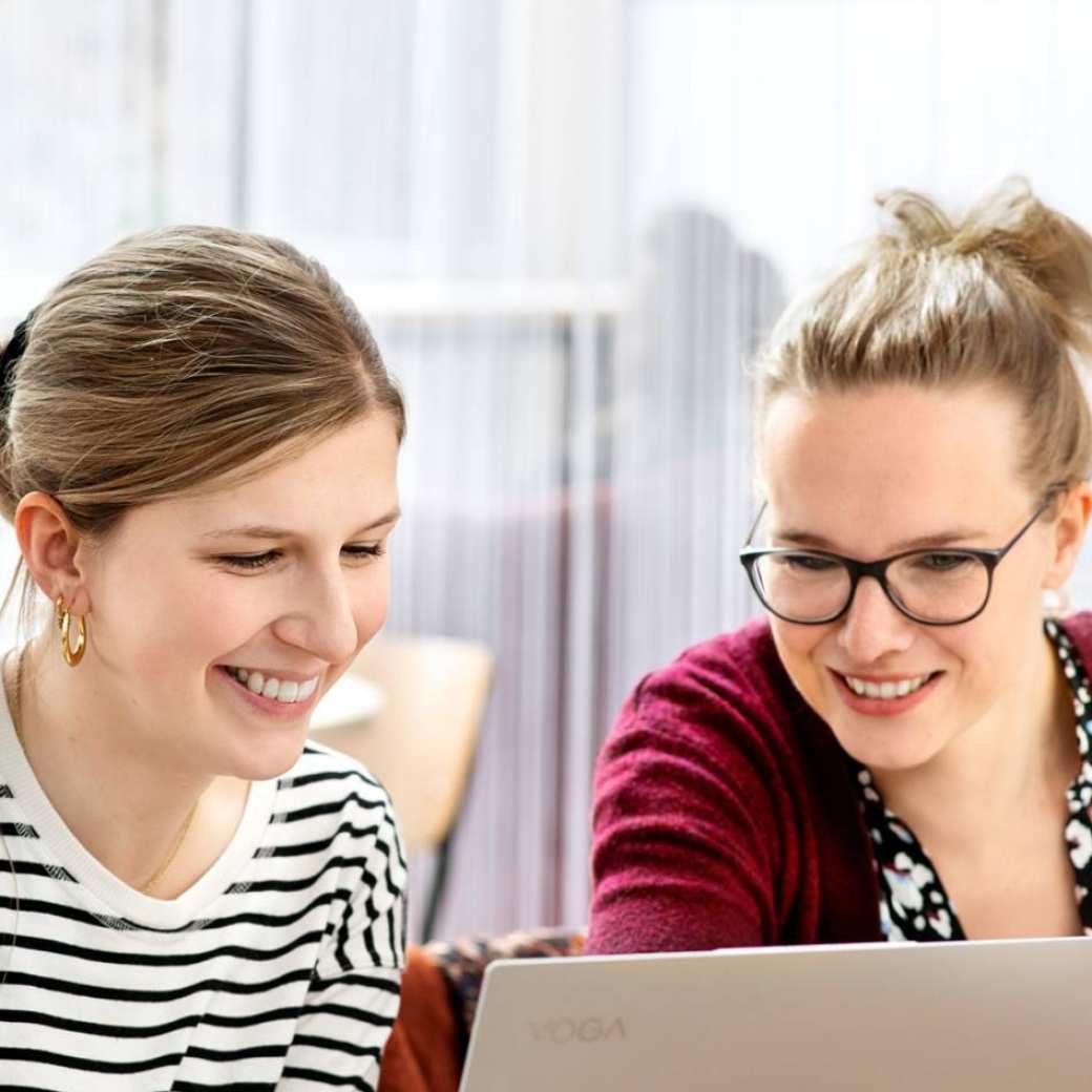 2 studenten kijken samen naar presentatie op laptop