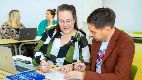 Docent legt iets aan haar leeerling