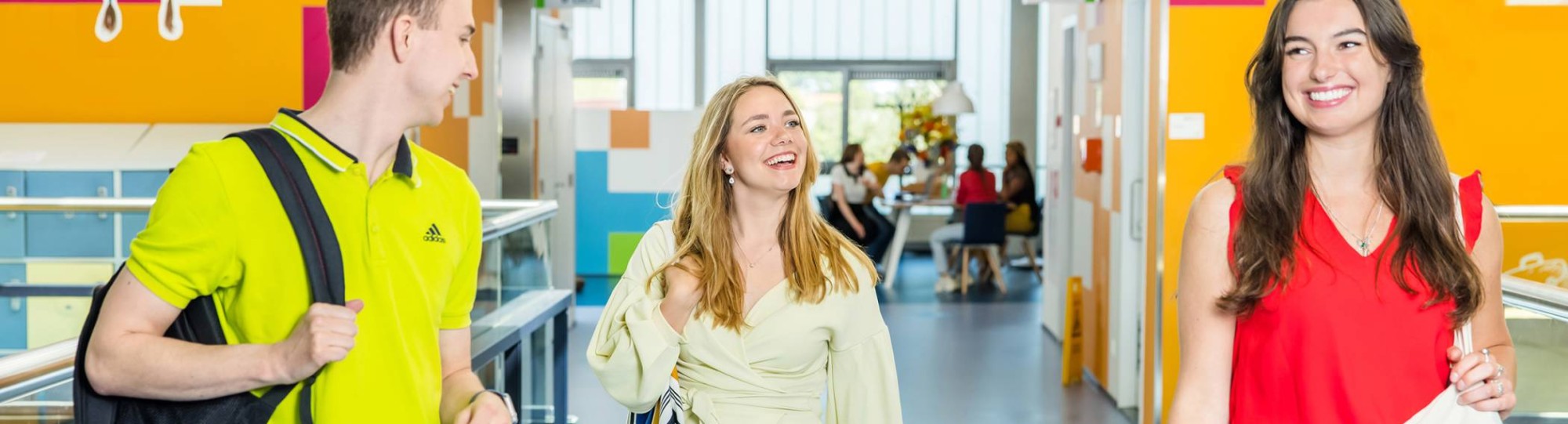 3 studenten wandelen op de gang van een HAN-gebouw