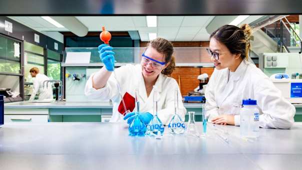 studenten pipetteren in het chemielab