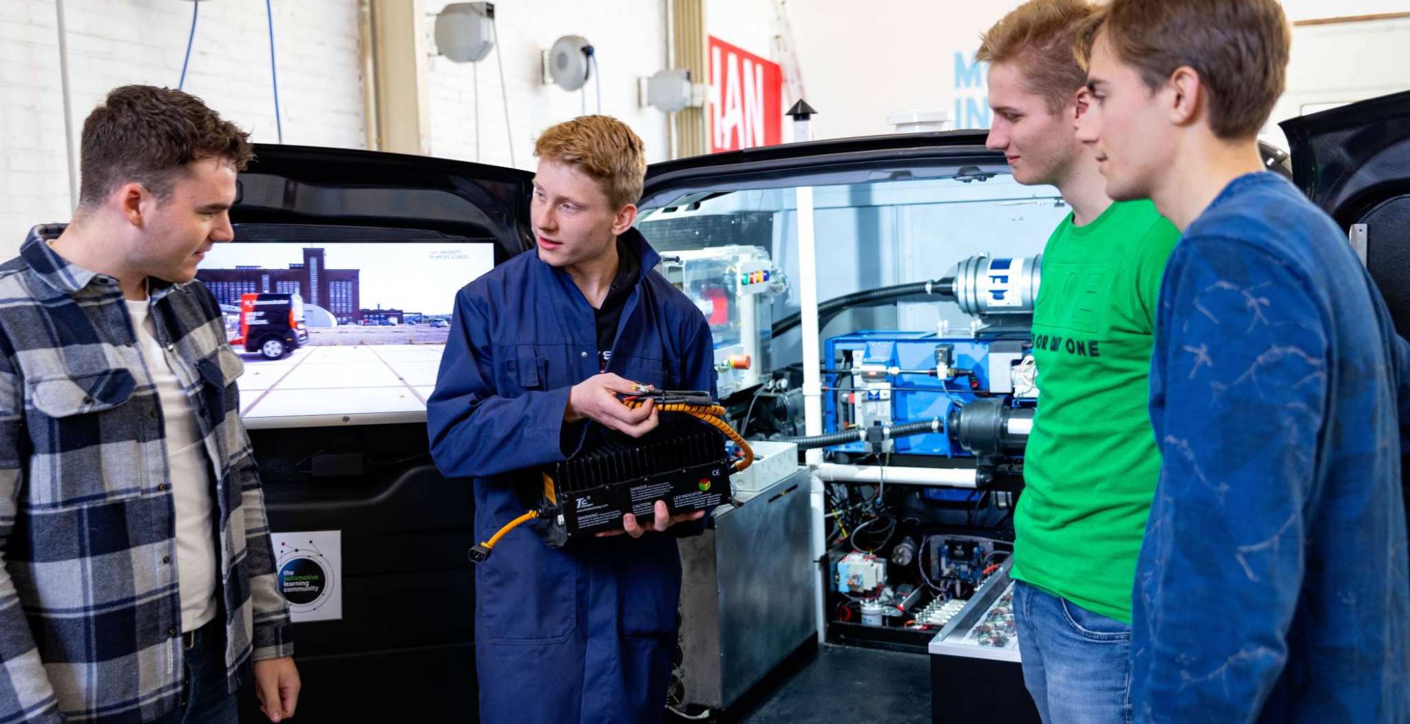 4 studenten voor de schterkant van de h2 demonstrator