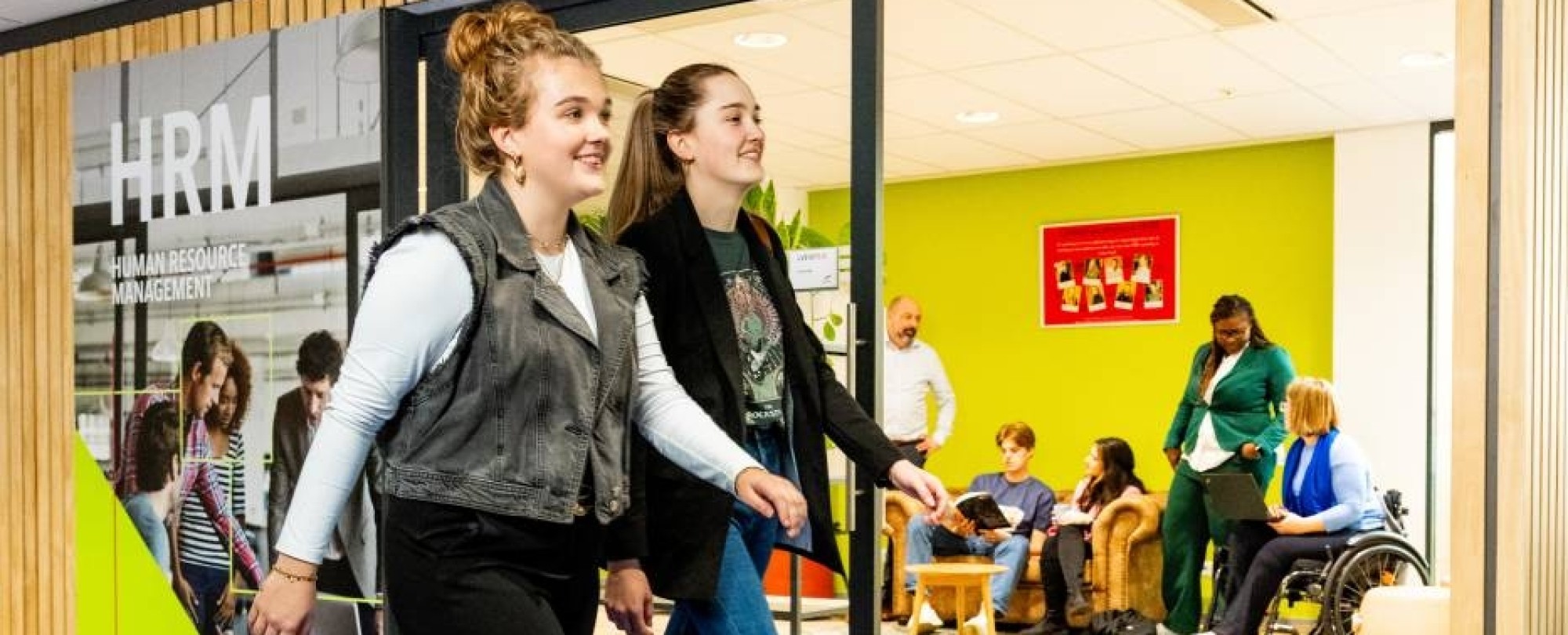 Studenten Human Resource Management (HRM) lopen op de gang voor de studio van de opleiding