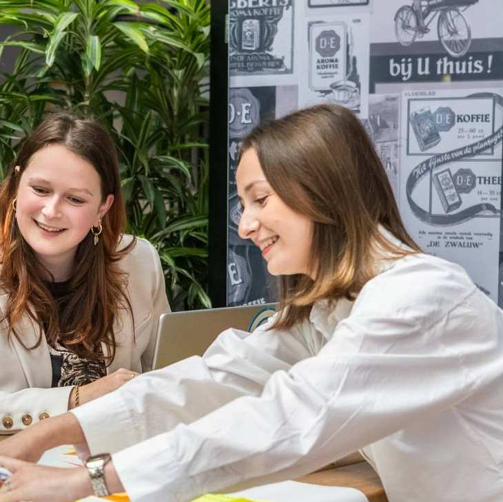 Commerciële Economie groep studenten en coach aan het werk