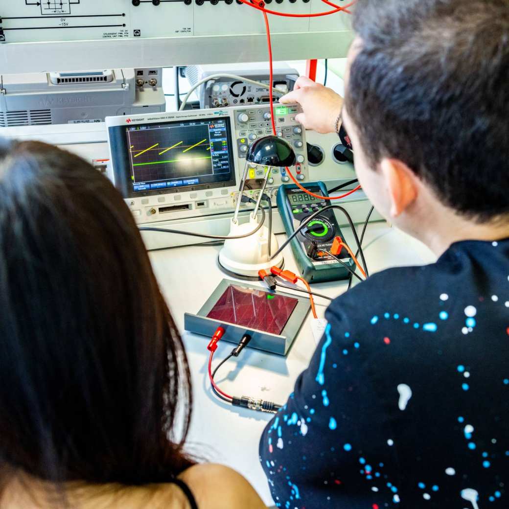 Twee studenten elektrotechniek doen een experiment met een zonnepaneel.