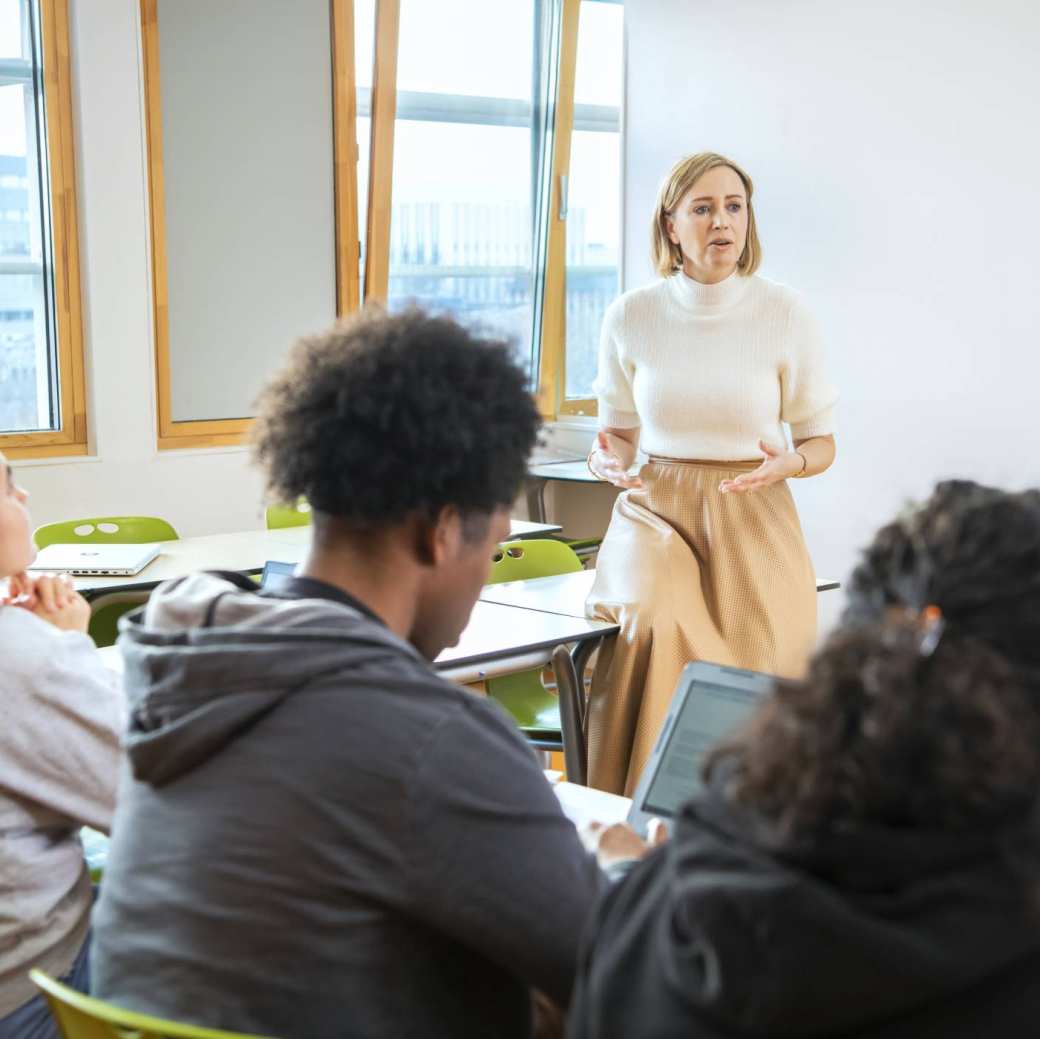 docent van de Educatie masteropleidingen geeft uitleg aan 3 studenten