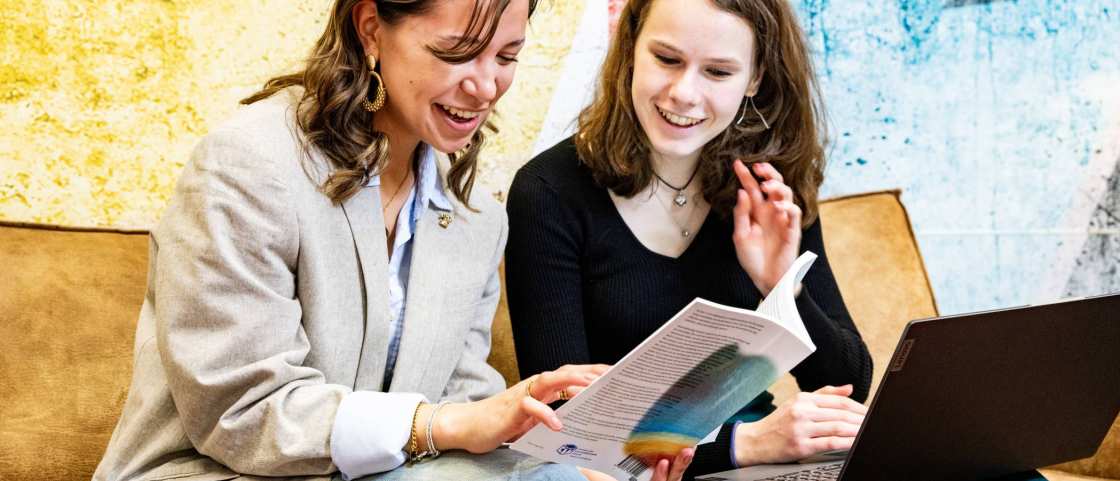 Studenten Learning and Development in Organisations (Opleidingskunde) lezen in een studieboek en hebben een laptop erbij