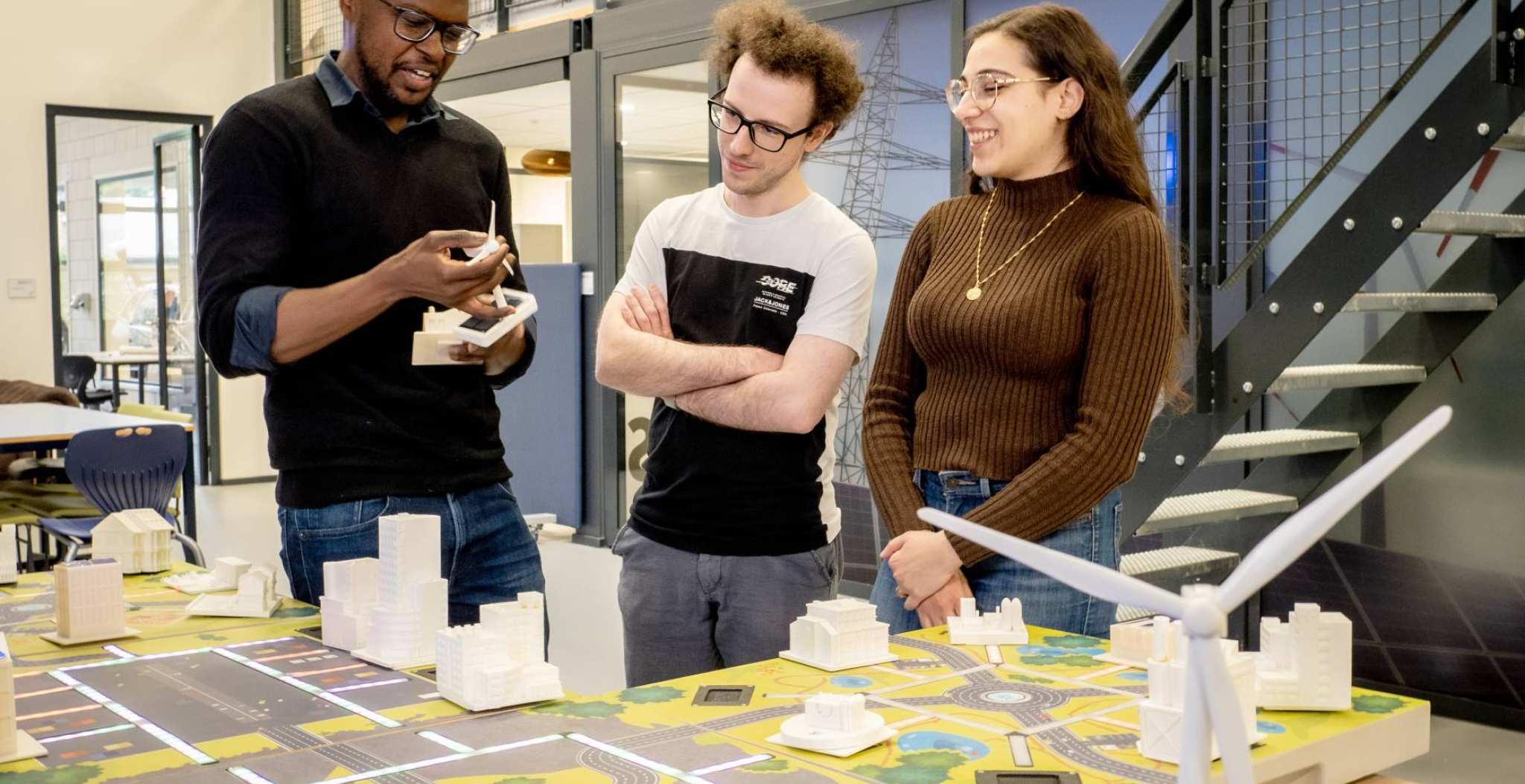 Studenten en een docent bij de smart grid demotafel