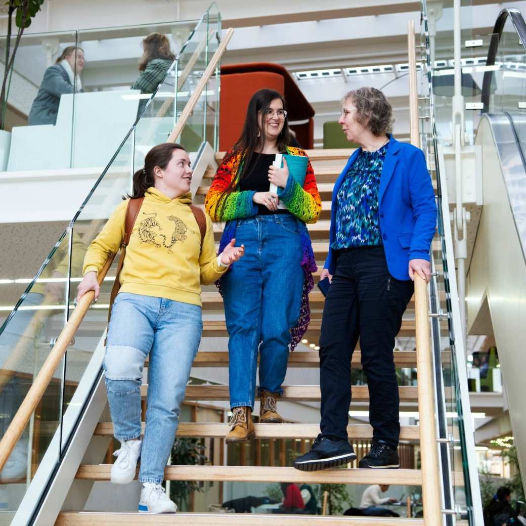 Foto Master Academie Educatie. 3 masterstudenten lopen de trap af terwijl ze praten op Kapittelweg 35, Nijmegen. 