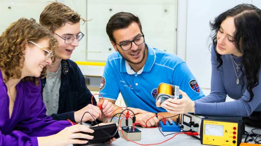 Vier studenten voeren een elektrisch circuit uit.
