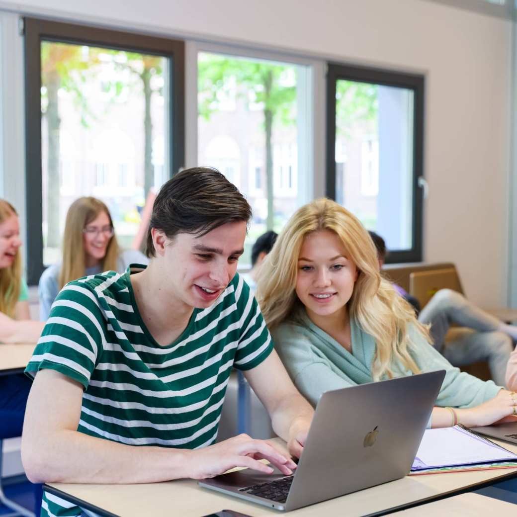 Foto Bedrijfskunde voltijd Nijmegen, klassetting, studenten samenwerken, laptops