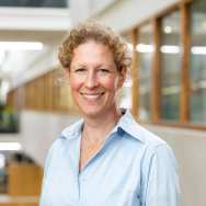 Portretfoto Ans Tordoir blauwe blouse dragend