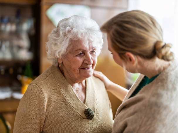 Verpleegkundige in gesprek met oudere vrouw