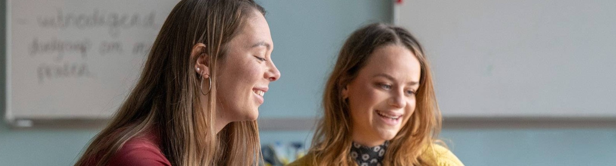 masterstudenten zitten naast elkaar naar de docent te luisteren in een oranje lokaal op Kapittelweg 35