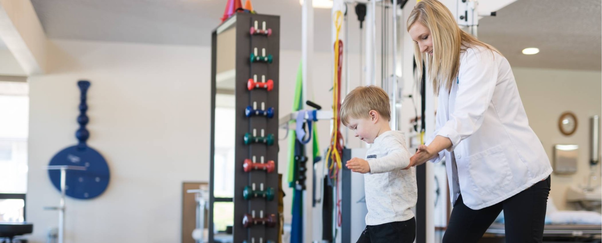 fysiotherapeut werkt met een jonge jongen in een open kliniek