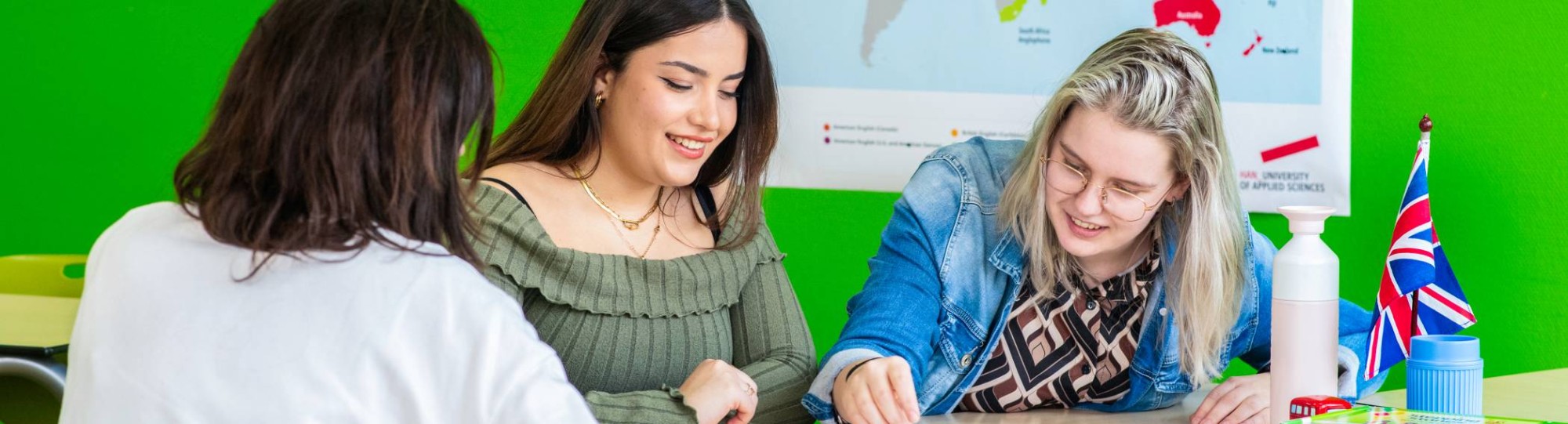 Drie studenten werken op één laptop in de open werkruimte in het I/O gebouw.