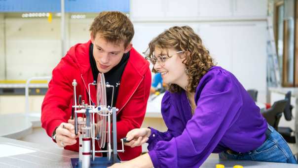 Twee studenten voeren een proef uit.
