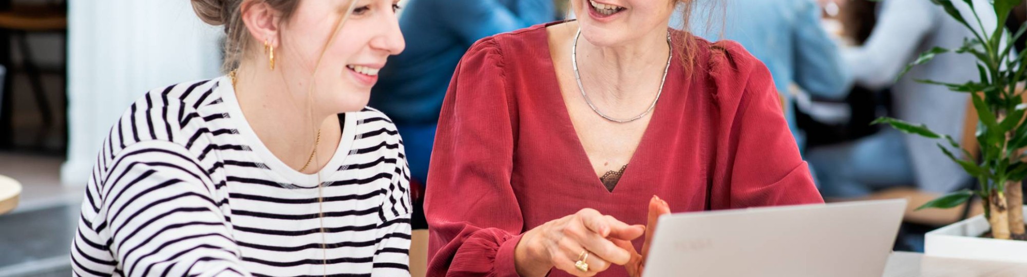 Docent in overleg met student met laptop