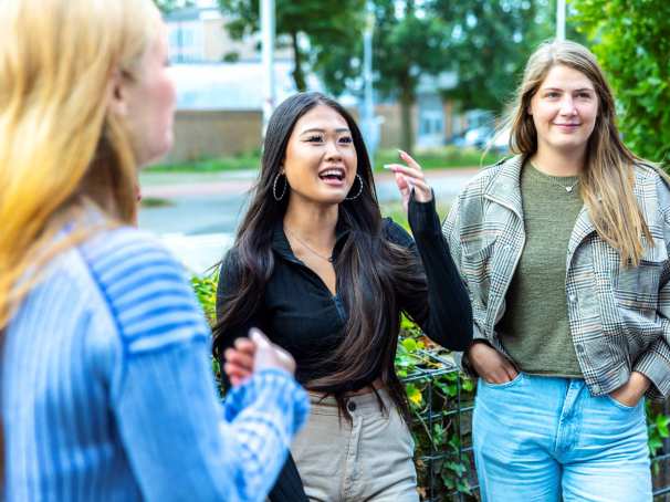 Een groep studenten HAN Social Work zijn samen buiten in gesprek.