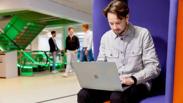 Medewerker Staf en Services aan het werk op een laptop.