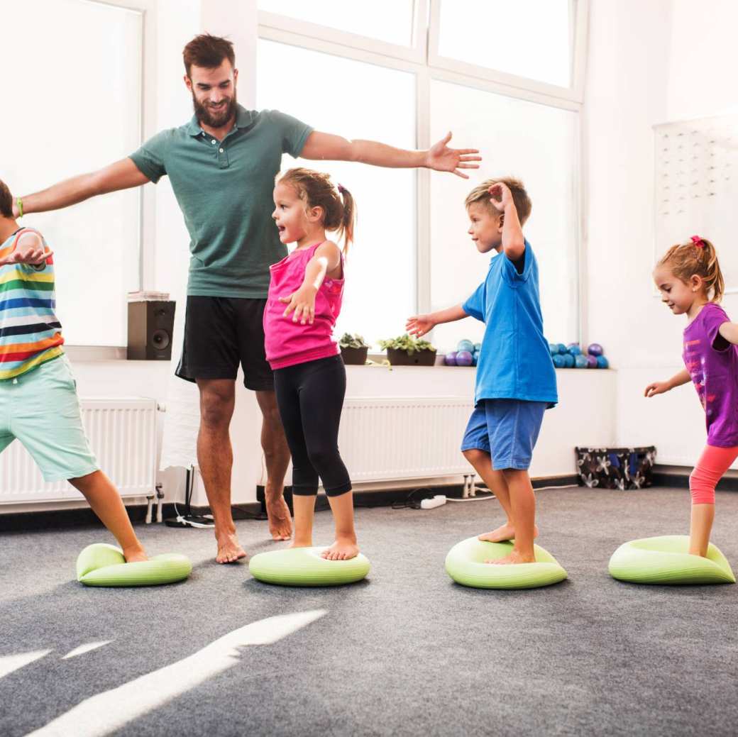 wandelen op pilates-ballen tijdens training op sportschool met mannelijke coach