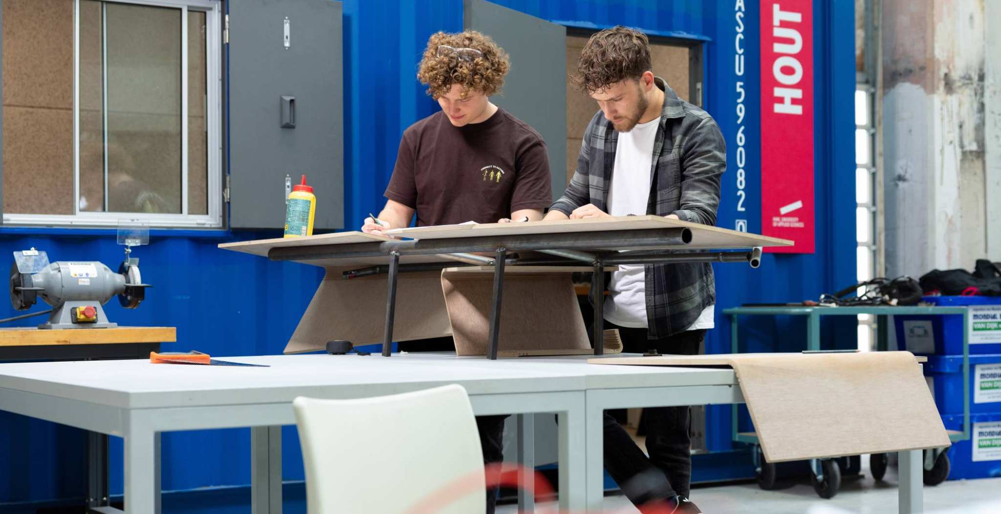 Samenwerken studenten. Houtwerkplaats, Mobility lab bij HAN Connectr op het IPWK. Drie studenten die samenwerken.