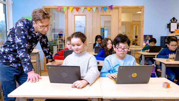 Groep 5,6,7 op de school Da Vince. 
De kinderen werken in de klas achter de laptop. 