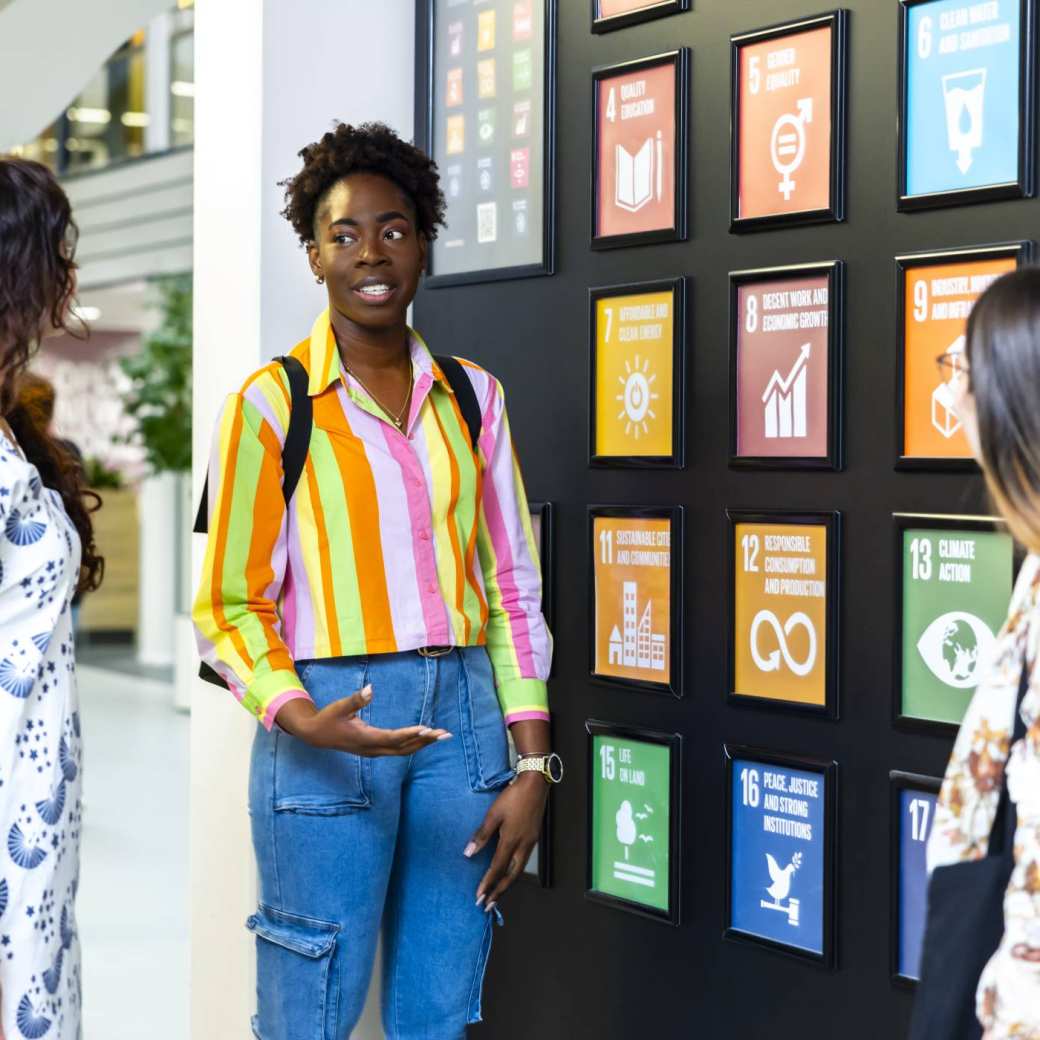 Studenten van de master Circular Economy bespreken de Sustainable Development Goals die op de HAN-campus hangen