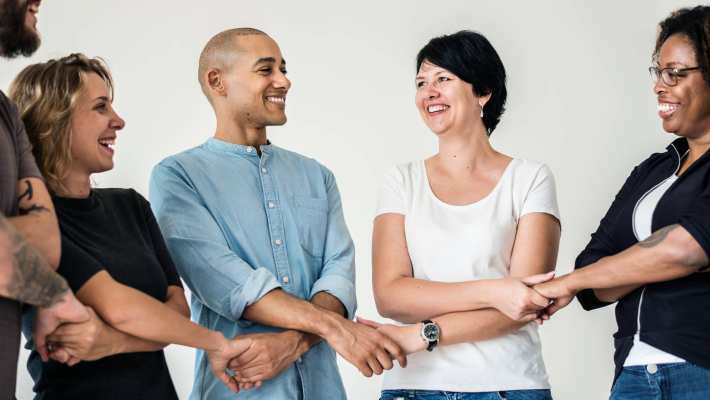 groep volwassenen die elkaars hand kruiselings vasthouden