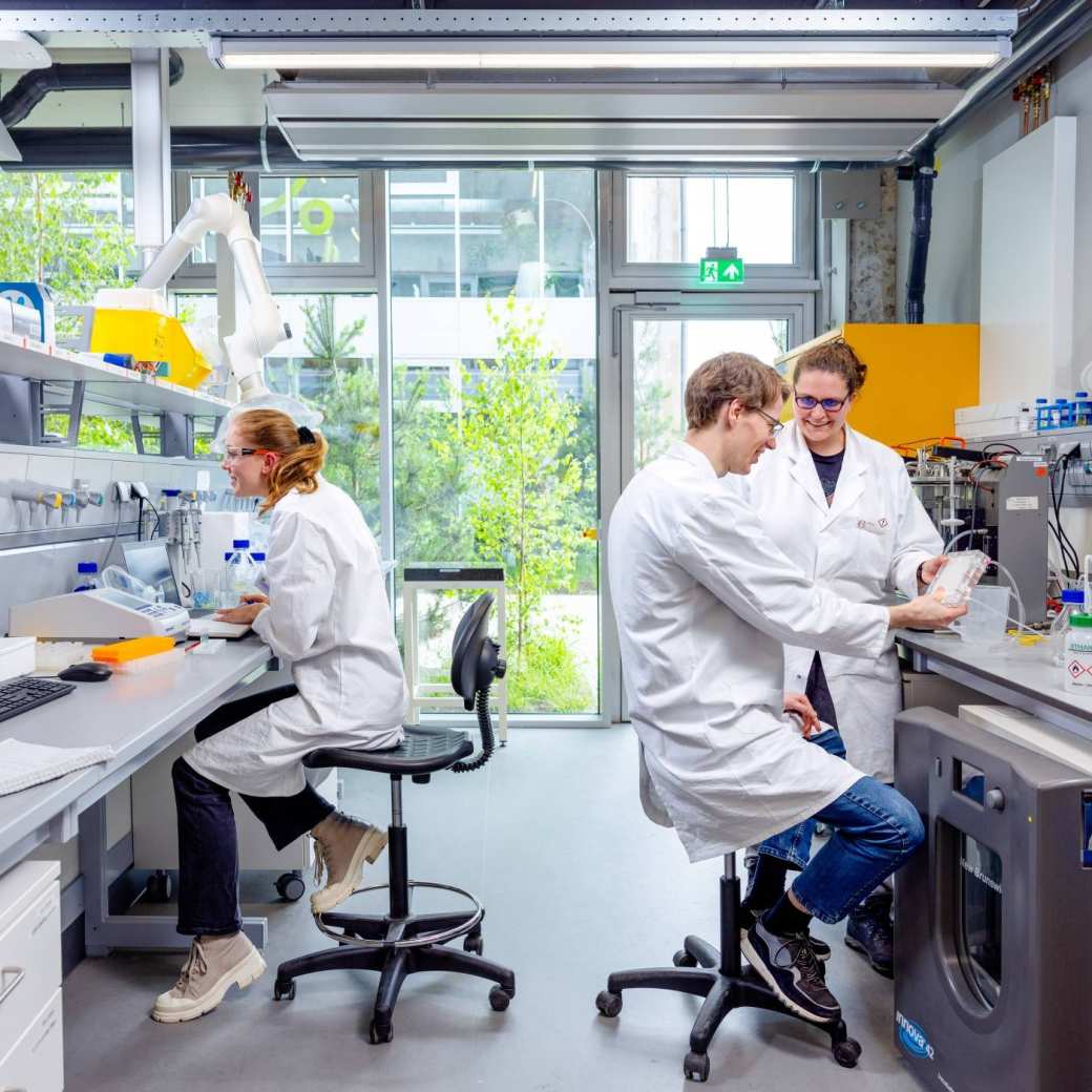 twee studenten en hun begeleider in een laboratorium