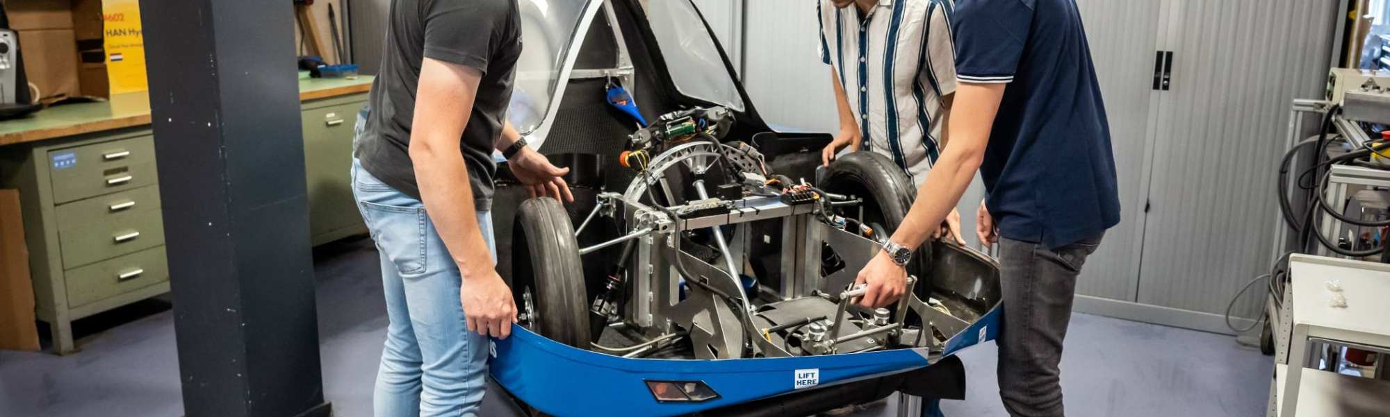 Drie studenten automotive werken samen aan het MH15 voertuig van de HAN.
