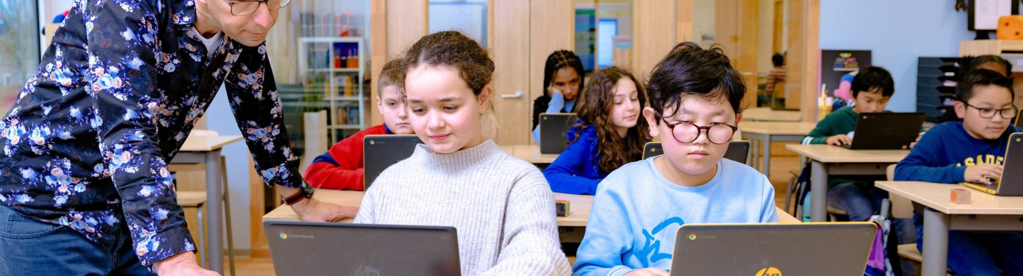 Groep 5,6,7 op de school Da Vince. 
De kinderen werken in de klas achter de laptop. 