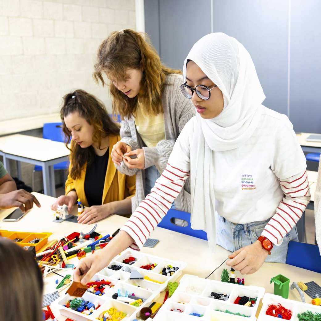 Studenten die met Lego werken in een les