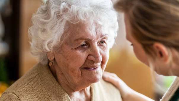 Verpleegkundige in gesprek met oudere vrouw