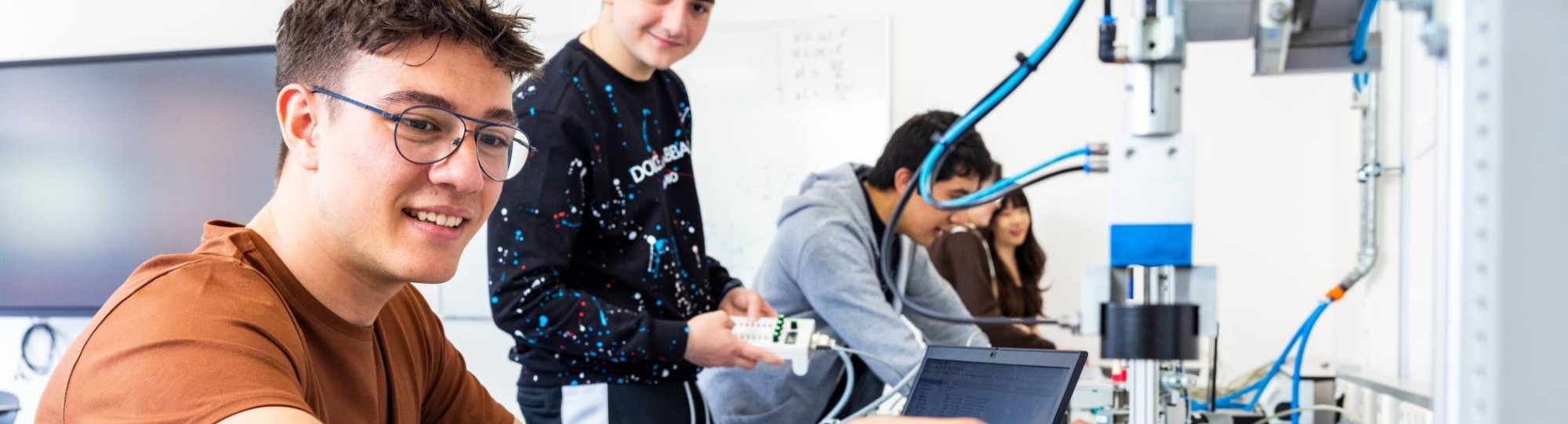 Twee elektrotechniekstudenten werken samen aan een PLC.