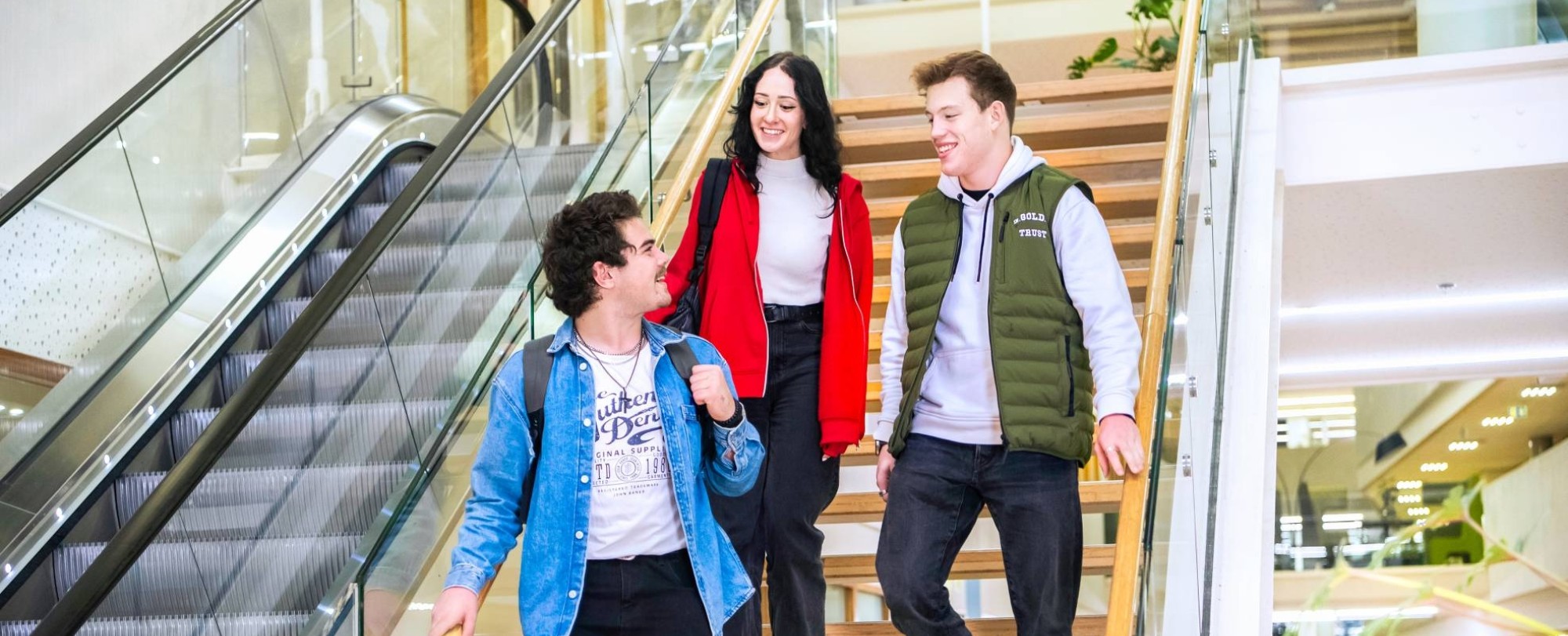 Drie studenten Leraar Natuurkunde lopen samen van de trap af.