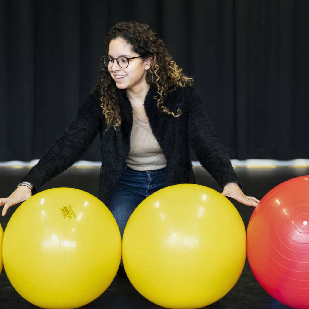 een student van de han master vaktherapie psychomotorische therapie doet een oefening met skippyballen in de gymzaal