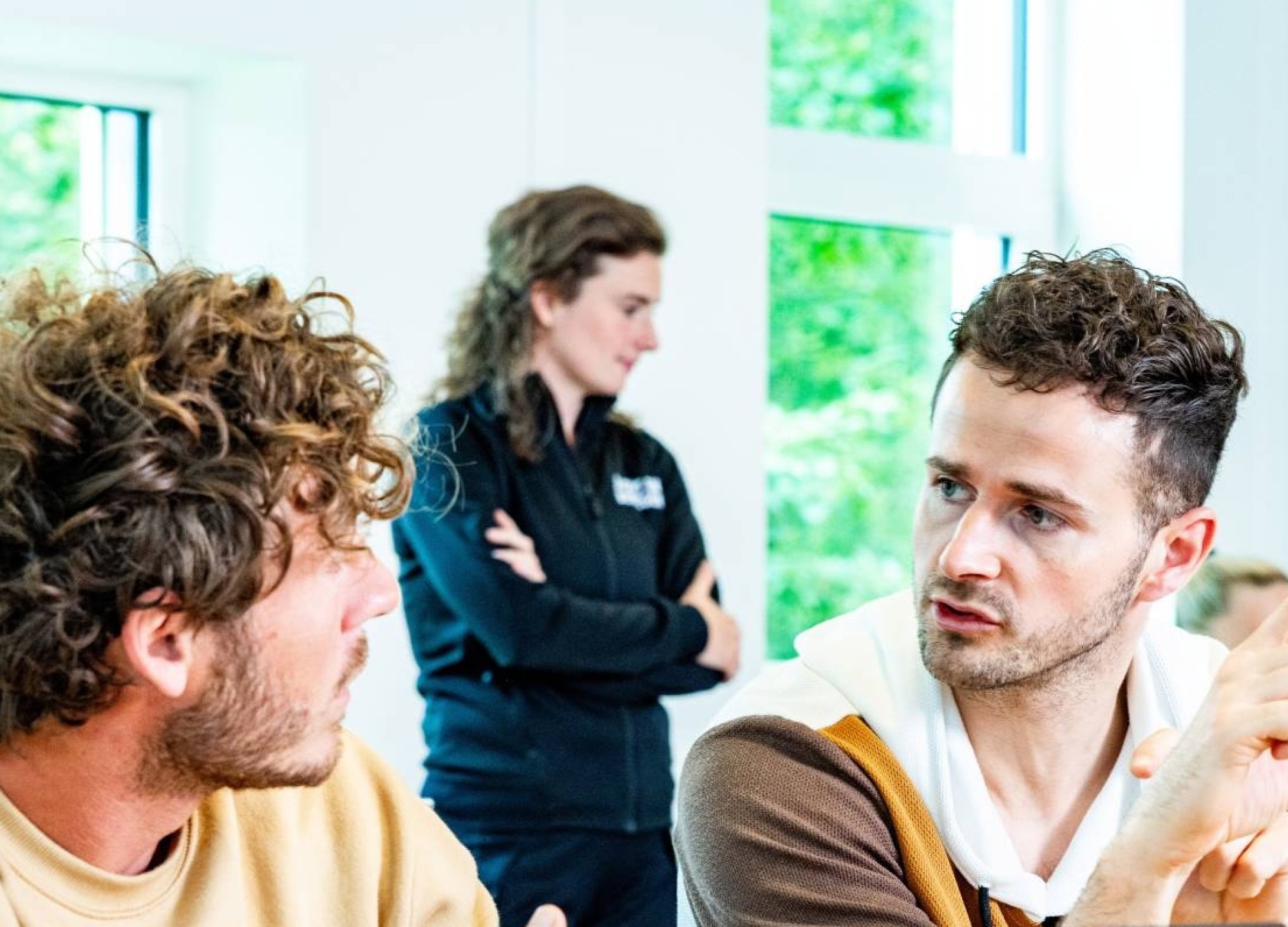 2 studenten die een module volgen overleggen met elkaar in een klaslokaal.