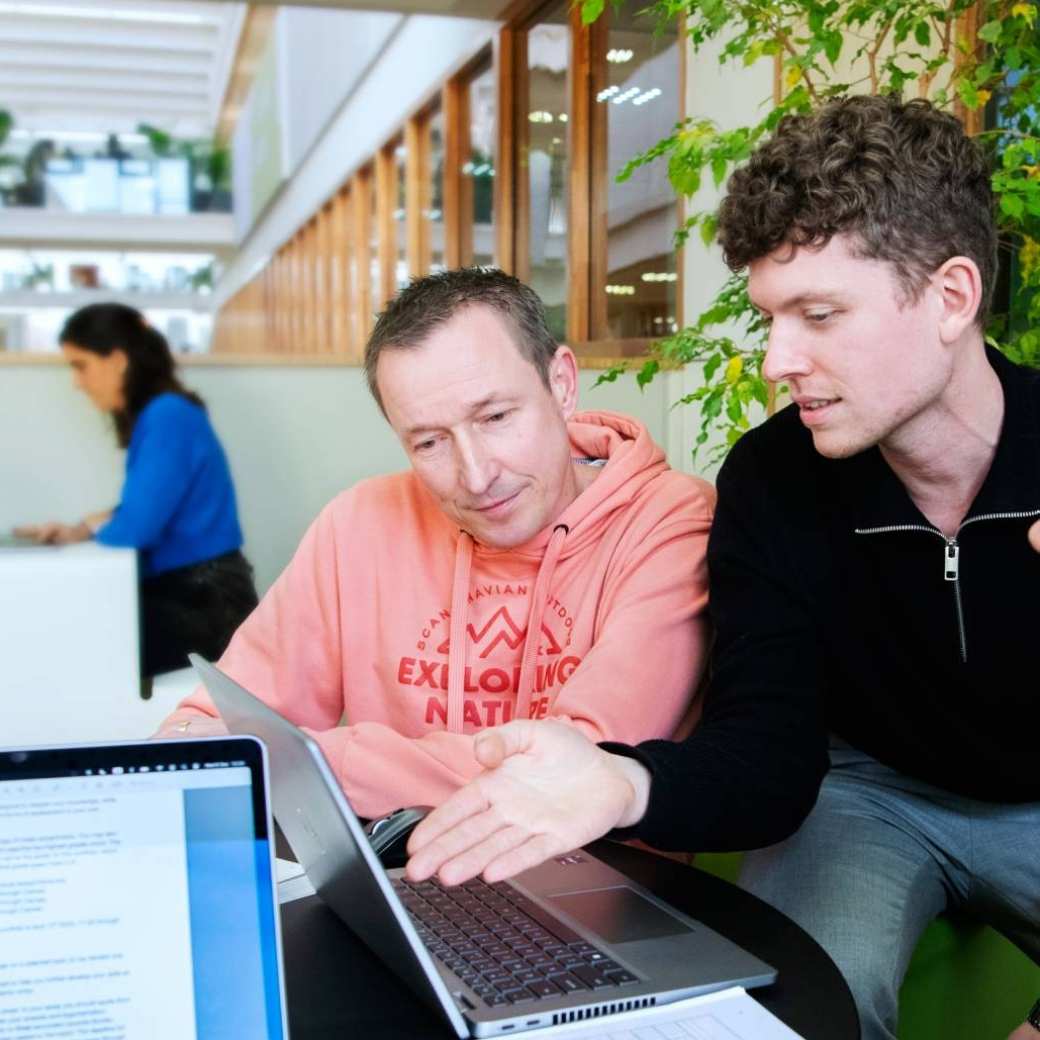 Foto Master Academie Educatie. 3 masterstudenten kijken op het laptopscherm van één van de 3 die ernaar wijst. 