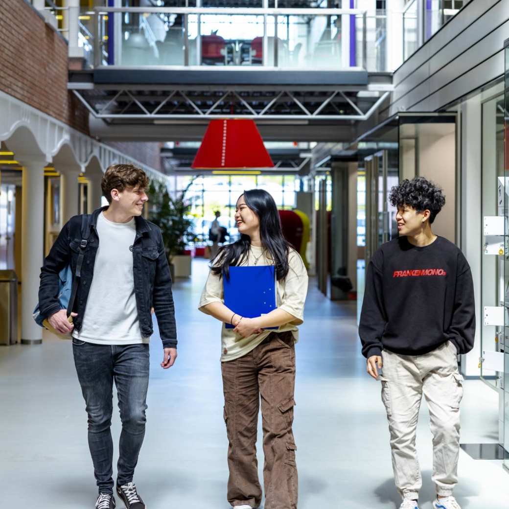 Communication HBO studenten lopen door de gang op de campus in Arnhem