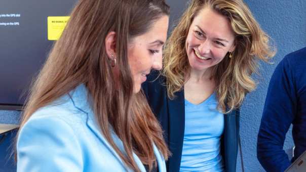 Vrouw is in gesprek met docent. Vrouw heeft lichtblauw jasje aan. Opleiding maag-, lever-, darmverpleegkundige